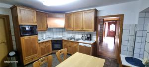 Casaba Suite -260 qm-2 floors- 7 Rooms-Free Private Parking-House with garden في هانوفر: مطبخ بدولاب خشبي وطاولة طعام +21 صورة