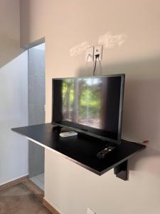 a flat screen tv sitting on a counter in a room at Casa Das Árvores BonitoMS in Bonito