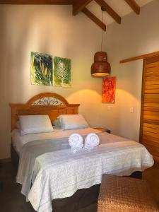 a bedroom with a bed with two towels on it at Casa Das Árvores BonitoMS in Bonito +27 photos