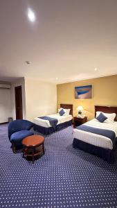 a hotel room with three beds and a couch at فندق عنيزة الحديث in Unayzah +26 photos
