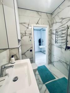 a bathroom with a sink and a toilet and a mirror at ЖК ДрімТаун Люкс апартаменти Євродвійка in Lutsk