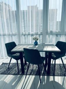 a dining room table with chairs and a large window at ЖК ДрімТаун Люкс апартаменти Євродвійка in Lutsk