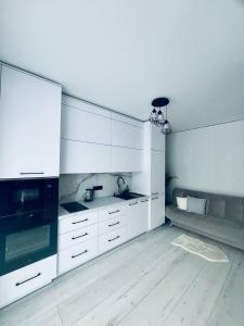 a kitchen with white cabinets and a black appliance at ЖК ДрімТаун Люкс апартаменти Євродвійка in Lutsk