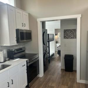 a kitchen with white cabinets and a black stove at Carolina Camp Cedar in Pickens