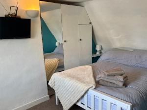 a bedroom with a bed with a mirror and a tv at Stylish Town House in Medieval Grid in Bury Saint Edmunds