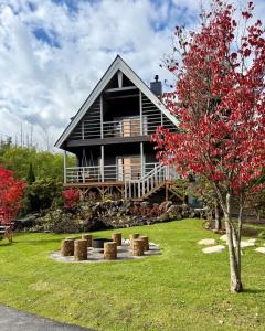 a large house with a tree in front of it at Best Day Ever Furano Lodges in Furano