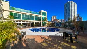 un edificio con piscina en frente de un edificio en Pietro Angelo Hotel, en Foz do Iguaçu