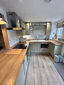 a kitchen with white cabinets and a wooden floor at Stylish Town House in Medieval Grid in Bury Saint Edmunds