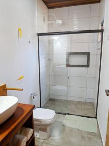 a bathroom with a shower with a toilet and a sink at Chalé em meio a natureza de bonitoms in Bonito +68 photos