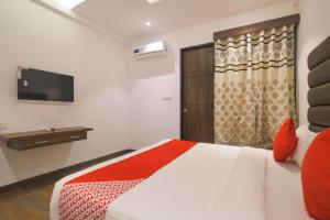 a hotel room with a bed and a television at Hotel O Rudraksh in Indore +28 photos
