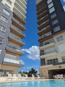 a pool in front of two tall buildings at Apt in luxurious condominium near the beach in Juan Dolio