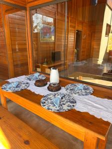 a table with plates and a lamp on top of it at Chalé em meio a natureza de bonitoms in Bonito