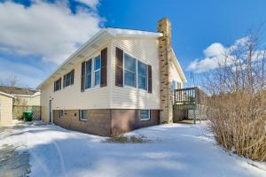 a white house with snow on the ground at Cozy Tawas City Home with Views of Lake Huron! in Tawas City