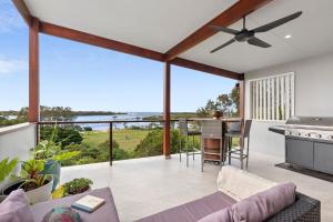 a living room with a ceiling fan and a view of the ocean at Urunga Magic. in Urunga