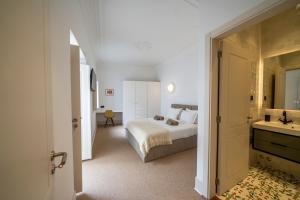 a bedroom with a bed and a bathroom with a sink at Good Old Days - Guesthouse in Caldas da Rainha