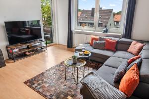 Una sala de estar con un sofá y un televisor. en NEU Ruhige und gemütliche Wohnung mit Balkon, en Hagen