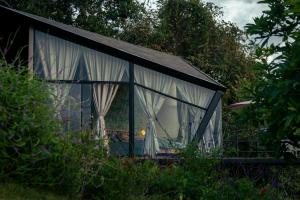 a small house with a window in a garden at Glamping Santuario in Calarcá