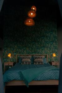 a bedroom with a blue bed with a green wall at Glamping Santuario in Calarcá