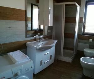 een badkamer met een wastafel, een toilet en een spiegel bij Appartamenti Vacanze Mareemare in Capo dʼOrlando
