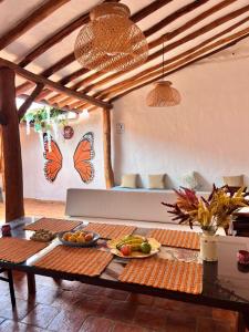 a living room with a table and butterflies on the wall at Habitación Vanessa, una ó dos personas in Barichara