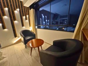 a room with two chairs and a table and a window at City Tower Hotel in Lima