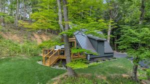 a tree house in the woods with a deck at High Peak At West Jefferson A Frame in West Jefferson