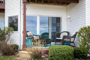 een veranda met rieten stoelen in een huis bij Coastal Serenity 108 Beachfront Condo Near Downtown in Fivemile Corner