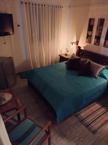 サン・フランシスコにあるCabaña Encanto de Lunaのベッドルーム(大きな緑のベッド1台、椅子付)