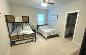 a bedroom with two bunk beds and a ceiling fan at The Tigers Pathway House near LSU Stadium - BC1034 in Collegetown