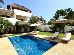 Villa mit einem Pool, 2 Stühlen und einem Sonnenschirm in der Unterkunft Villa Margarita Bungalow in Brisas de Zicatela
