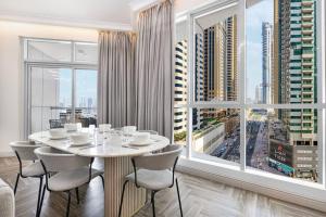 a dining room with a table and a large window at StayMada - Torch Tower Elegant Marina Retreat in Dubai
