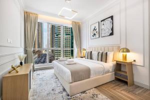 a white bedroom with a bed and a large window at StayMada - Torch Tower Elegant Marina Retreat in Dubai +44 photos