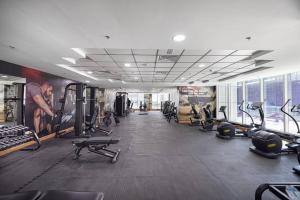 a gym with several treadmills and machines in a room at StayMada - Torch Tower Elegant Marina Retreat in Dubai