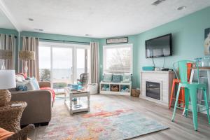 een woonkamer met een bank en een tv bij Sandy Haven 109 Direct Beach Access Downtown Tart Trail in Fivemile Corner