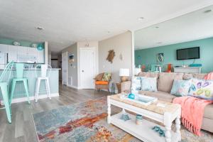 een woonkamer met een bank en een tafel bij Sandy Haven 109 Direct Beach Access Downtown Tart Trail in Fivemile Corner