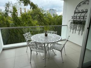 a table and chairs on a balcony with a window at Exclusivo Apartamento en Panoramika Laureles Rodeado de Naturaleza in Armenia