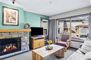 ein Wohnzimmer mit Kamin und Fernseher in der Unterkunft Rockies Getaway 2BR with Patio Hot Tub and Gym in Dead Man's Flats