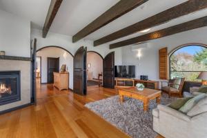 un salon avec un canapé et une cheminée dans l'établissement Ultimate Lakefront Getaway, à Waitahanui