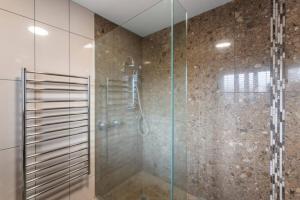 une salle de bain avec une douche avec une porte vitrée dans l'établissement Ultimate Lakefront Getaway, à Waitahanui 27 autres photos