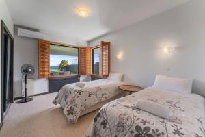 une chambre avec deux lits et une fenêtre dans l'établissement Ultimate Lakefront Getaway, à Waitahanui