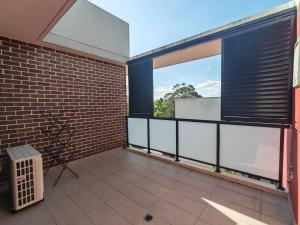 a balcony with a brick wall and large windows at Modern 2BR apartment in Asquith in Asquith