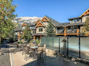 a patio with a table and chairs in front of a house at Cozy Oasis 2BR with Hot Tub and Gym 10 Mins to DT in Dead Man's Flats