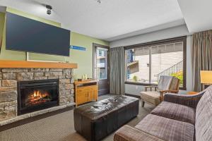 a living room with a fireplace and a tv at Cozy Oasis 2BR with Hot Tub and Gym 10 Mins to DT in Dead Man's Flats +33 photos