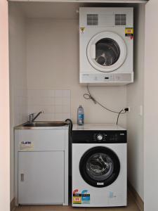 a kitchen with a washing machine and a microwave at Modern 2BR apartment in Asquith in Asquith