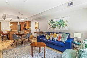 a living room with a blue couch and a kitchen at Contemporary 2BR with hot tub and Mountain Views in Dead Man's Flats