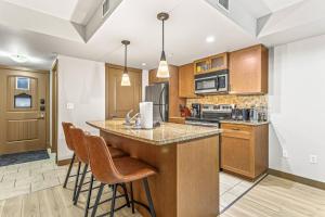 a kitchen with a island with bar stools at Contemporary 2BR with hot tub and Mountain Views in Dead Man's Flats