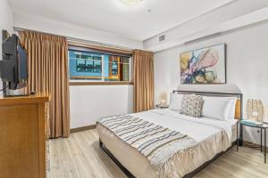 a bedroom with a bed and a tv and a window at Contemporary 2BR with hot tub and Mountain Views in Dead Man's Flats