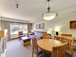 a living room with a table and a couch at Cozy Condo With Hot Tub Gym and Underground Parking in Dead Man's Flats