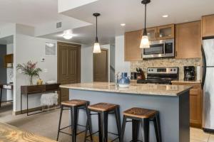 a kitchen with a large island with bar stools at Lovely 3BR condo with Hot Tub at the Edge of Canmore in Dead Man's Flats