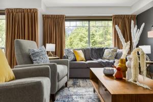 a living room with a couch and a table at Lovely 3BR condo with Hot Tub at the Edge of Canmore in Dead Man's Flats